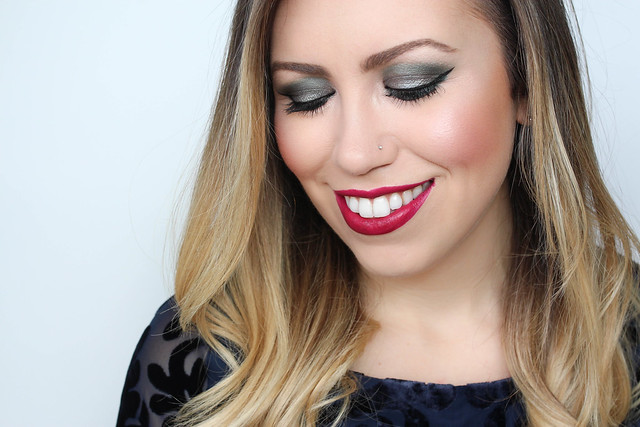 woman smiling showing Festive Green Eyeshadow and red lipstick
