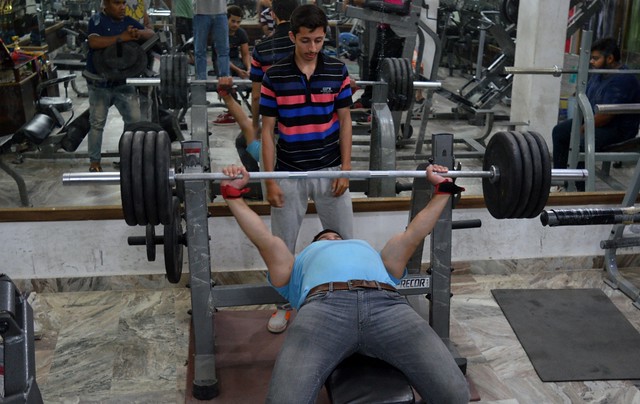 Adil working out in gym.