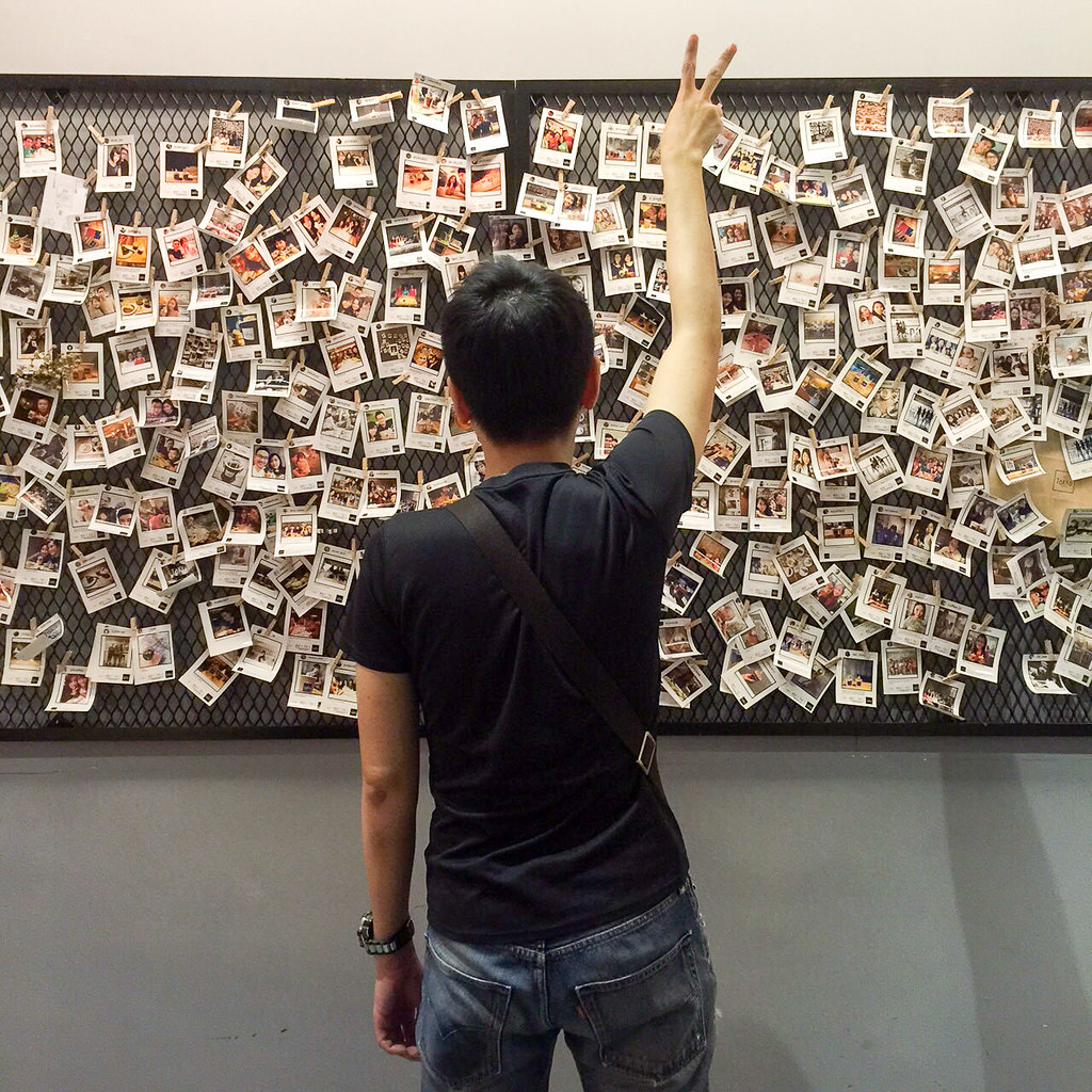 Someone posing with all the printed photos at P.S. Tokyo
