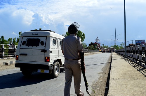 J&K Police Officer chasing protestors with a pellet gun (Photo By_ Raqib Hameed Naik).JPG