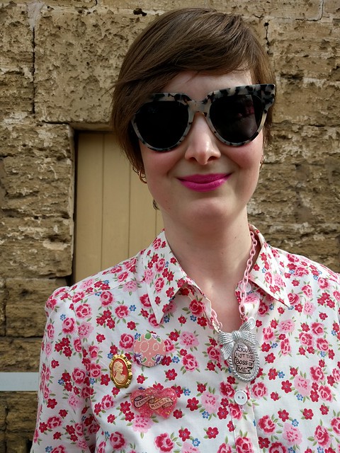A close up of a woman in a floral print shirtdress.