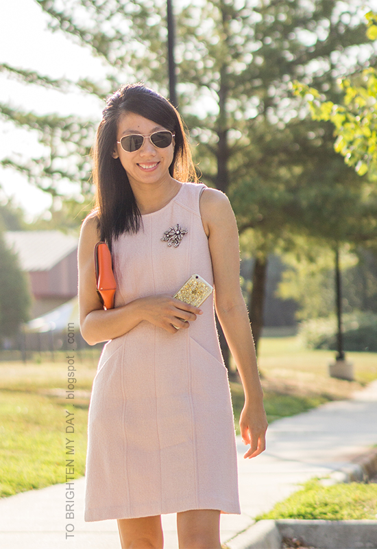 sparkly brooch pinned on pink wool shift dress, orange clutch