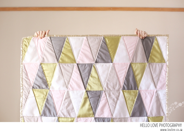 A soft tone girl's nursery with triangle quilt